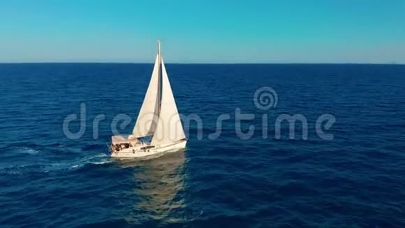 在海洋中的帆船白色帆船在无边无际的海洋中间空中观景视频的预览图