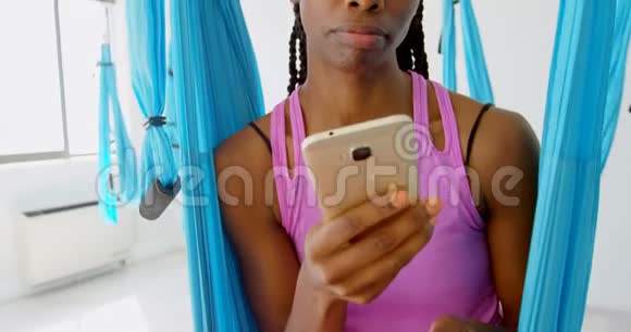 女人坐在吊床上荡秋千时在用手机说话视频的预览图
