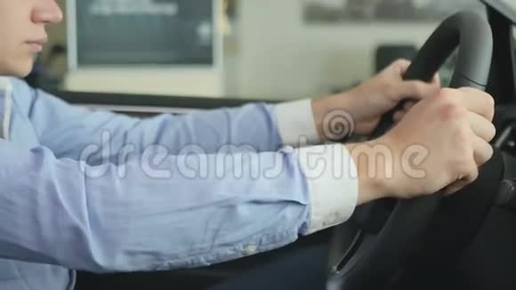 那人坐在车里双手握在方向盘旁视频的预览图