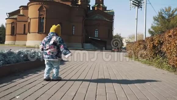 一个小孩独自走在秋天的公园里视频的预览图