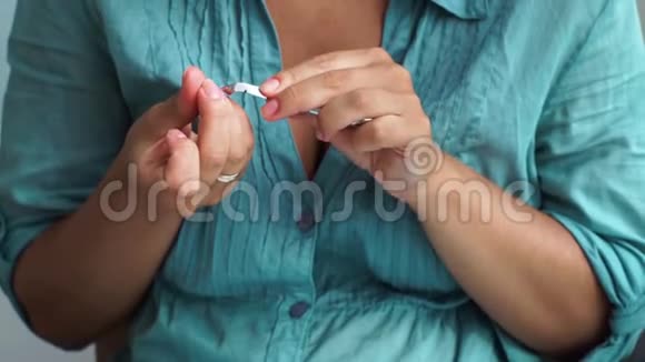女性修剪角质层而家庭指甲使用角质层镊子关闭美甲护理理念女人在视频的预览图