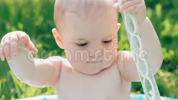 一个阳光明媚的夏天小男孩在充气游泳池里玩耍视频的预览图