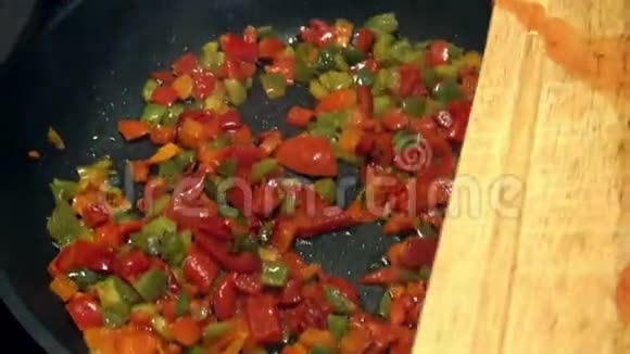 厨师在煎锅里用西红柿烹制美味的红椒和青椒视频的预览图