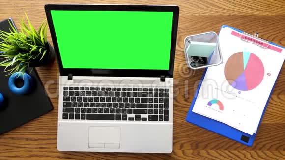 顶部的书桌笔记本电脑旁边有彩色绿色屏幕视频的预览图