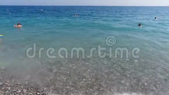4k家庭游客和当地人在法国里维埃拉南部海岸著名的尼斯卵石海滩日光浴和放松视频的预览图