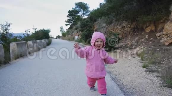 淘气的白种人婴儿在引擎盖与赫伯斯特罗笑着跑在山路上试图追逐相机快乐视频的预览图