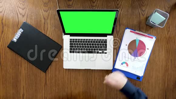 一个人在办公室工作办公桌上放着绿屏电脑视频的预览图