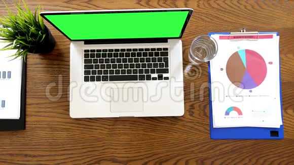 带有绿色屏幕的笔记本电脑和桌子上的两个剪贴板视频的预览图
