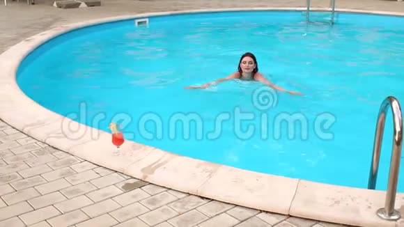 穿黑色泳衣的女孩在游泳池里游泳视频的预览图