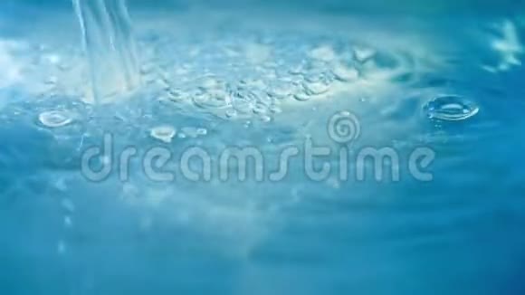 在蓝色背景上缓慢地关闭干净的水喷溅和气泡视频的预览图