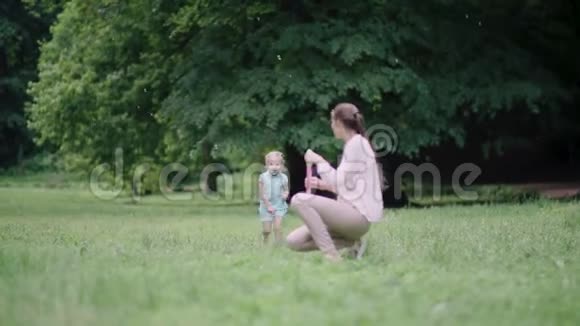 家庭娱乐妈妈和孩子在户外做肥皂泡视频的预览图