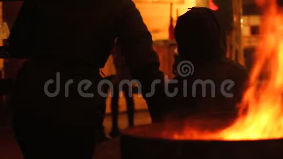 人们在寒冷的秋夜户外围着火晒太阳喝饮料视频的预览图