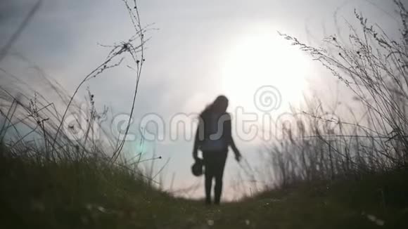 夕阳西下年轻的女性在田野上行走视频的预览图