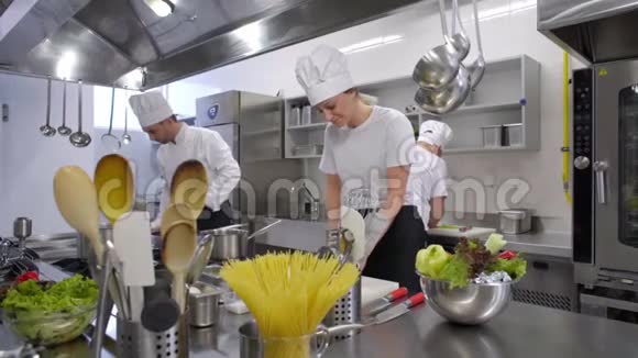忙碌的厨师和厨房厨师在专业厨房工作视频的预览图