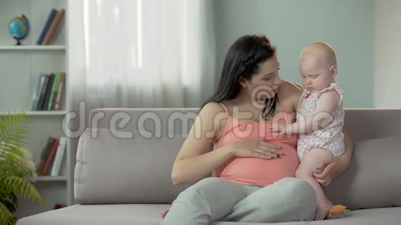 年轻的女士怀着孩子享受和小宝宝在一起的时光快乐的母亲视频的预览图