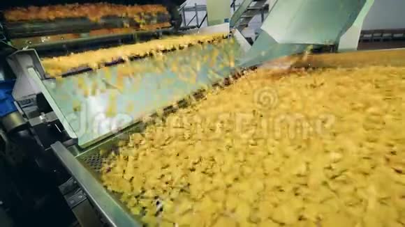 土豆薯片在工厂里油炸在自动输送机上移动视频的预览图