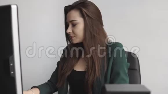 布鲁内特女士在办公室的一个班长面前工作商务女性在同事间的电脑工作视频的预览图