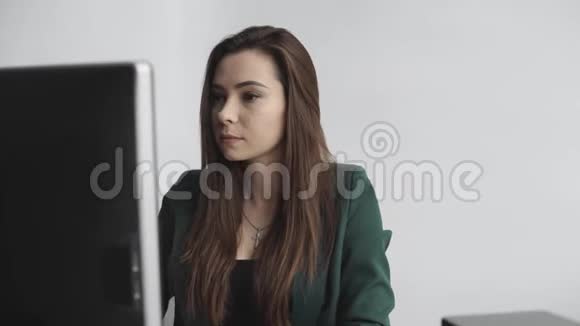 布鲁内特女士在办公室的一个班长面前工作商务女性在同事间的电脑工作视频的预览图