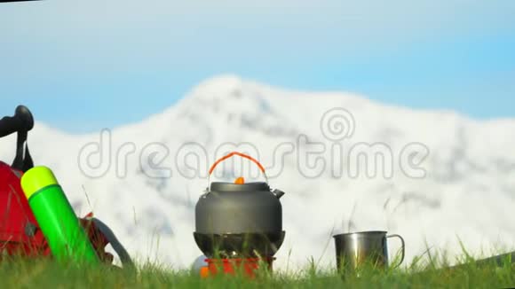 在青山上煤气炉上的茶壶沸腾了红色背包附近躺着视频的预览图
