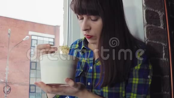 那个女孩坐在窗台上靠在砖楼上吃方便面视频的预览图