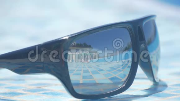 海滩上有蓝色海洋背景的太阳镜夏天侧视选择性聚焦旅行者梦想的概念视频的预览图