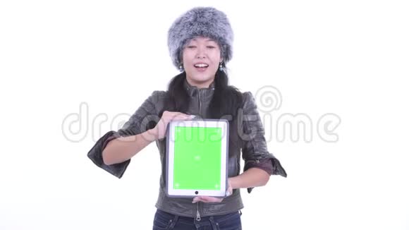 快乐美丽的亚洲女人说话展示数字平板电脑视频的预览图