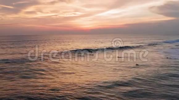 冲浪者乘坐日落海浪的鸟瞰图无人机4k射击冲浪海洋生活方式极限运动视频的预览图