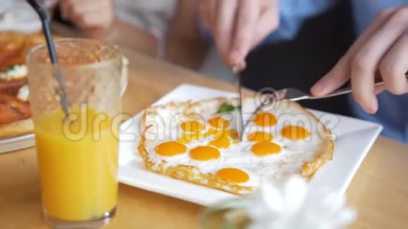 男人的手用餐刀和叉子切一个好吃又有用的煎蛋视频的预览图