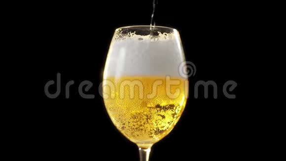 金色泡沫啤酒慢慢倒入玻璃杯黑色背景下的啤酒杯啤酒中的气泡淡啤酒视频的预览图