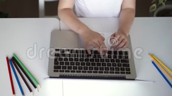 无法辨认的小女孩在房间里的笔记本电脑上打字视频的预览图