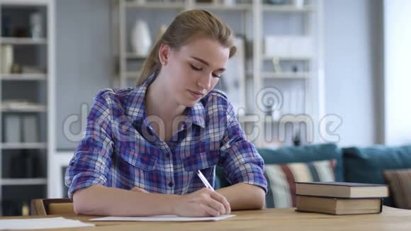 文书工作年轻妇女在办公桌前写作视频的预览图