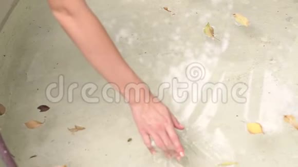 女孩牵着一只手穿过喷泉里的水视频的预览图