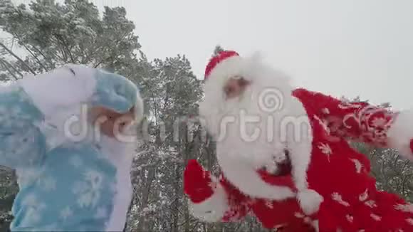 圣诞老人和他的孙女雪少女在冬天玩得很开心跳舞快速射击视频的预览图