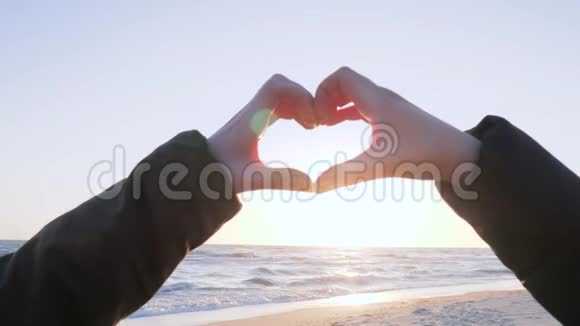 人们的手臂在海岸日落时使人心向天堂视频的预览图
