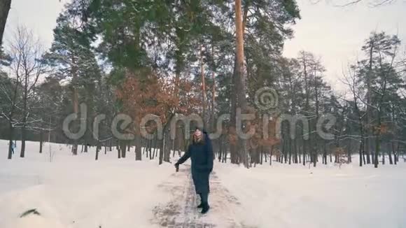 红姜发女走在雪地公园冬晚4K视频的预览图