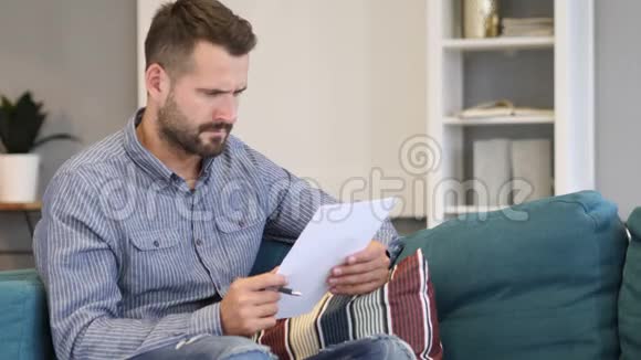 Penisve男子阅读协议坐在沙发上视频的预览图