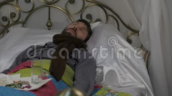 一个病人躺在床上脖子上戴着一条温暖的围巾头上戴着一条毛巾视频上和医生聊天视频的预览图