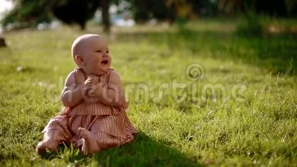 坐在草地上的女婴肖像视频的预览图