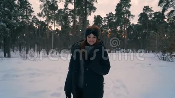红姜发女走在雪地公园冬季视频的预览图