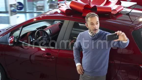 那个在汽车背景上自拍的可爱男人视频的预览图