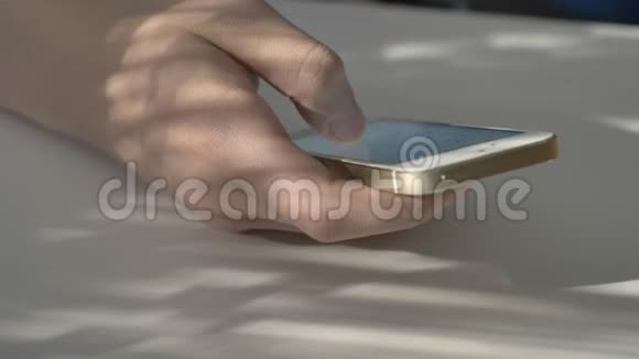 男人白色智能手机上的手滚动日历打字屏幕上的阳光反射概念一张阳光明媚的桌子视频的预览图
