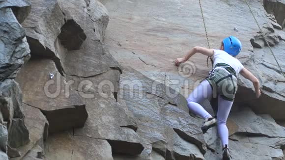 一位女性攀岩者爬上岩石学着爬摇滚女孩登山视频的预览图