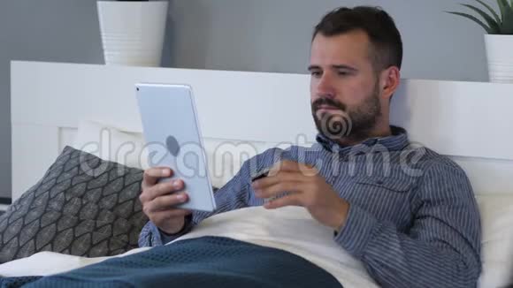 躺在床上的疲惫的男人在网上购物视频的预览图