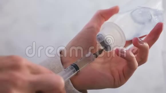 女人拿起注射器用生理盐水吸入双手特写视频的预览图