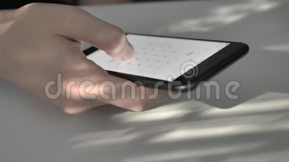 男人手在黑色的大智能手机上滚动日历打字屏幕上的阳光反射概念阳光明媚视频的预览图