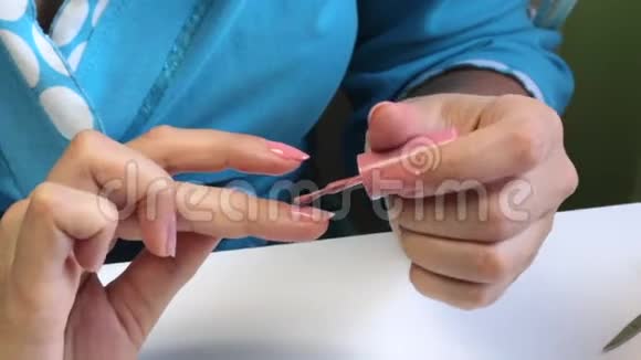 女人做指甲用刷子在指甲上刷凝胶视频的预览图