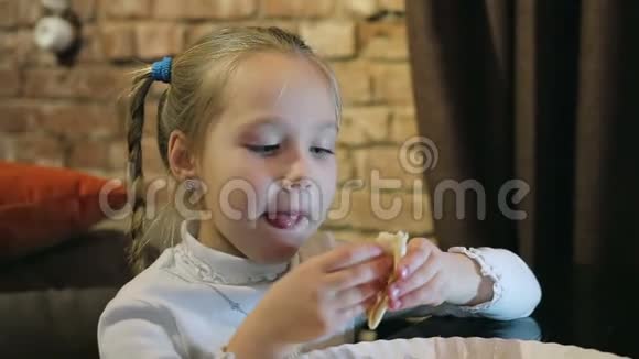 咖啡馆里的小女孩正用手吃披萨视频的预览图