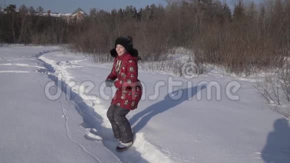 在冬季公园里十几岁的女孩掉进了雪地里慢镜头录像视频的预览图