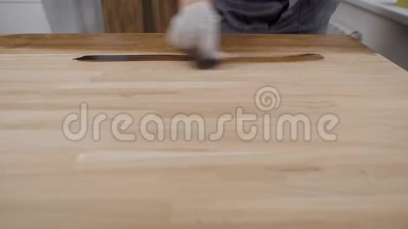 整体工人和手套工人在室内为木制面板涂油视频的预览图