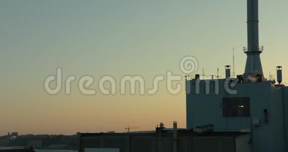 日落时的工厂屋顶烟囱里冒出浓烟视频的预览图
